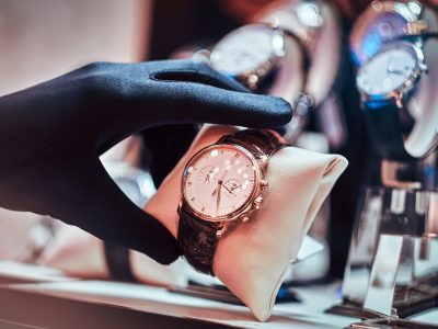 Close-up of the seller's hand in gloves shows the exclusive men's watch from the new collection