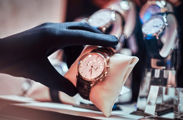 Close-up of the seller's hand in gloves shows the exclusive men's watch from the new collection