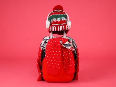 A suitcase with a sweater, a hat and headphones